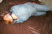 Katharina tied and gagged on a bed wearing sexy shiny grey downwear (Pics)