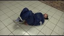 Jill tied and gagged on the floor in an old cellar wearing a shiny blue PVC sauna suit (Video)