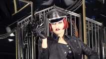 Mistress Tokyo smoking cigarette in leather, gloves and Muir Cap; fetish, POV