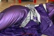 Alina tied, hodded and gagged on the floor in an purple/silver shiny PVC suit (Pics)