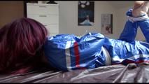 Mara tied and gagged on bed wearing s shiny blue PVC sauna suit (Video)