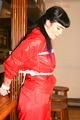 Jill tied and gagged on a pillar wearing a shiny red rainwear (Pics)