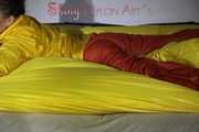 Watching Sandra wearing supersexy shiny nylon rainwear in yellow and orange preparing her bed and lolling in it with this shiny rainwear (Pics)