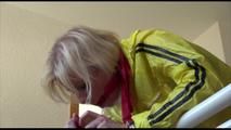 Pia tied and gagged on a stairway with cuffs wearing a sexy red/yellow shiny nylon shorts and a yellow rain jacket (Video)