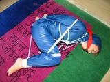 one of our archive girls tied and gagged in a shiny nylon rainsuit