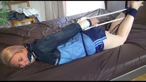 Mara tied and gagged with ropes on bed wearing a lightblue oldschool shiny nylon shorts and an oldschool lightblue/blue rain jacket (Video)