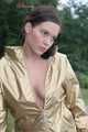 Watching out beautiful archive girl wearing a white shiny nylon shorts and a golden rain jacket posing outdoor (Pics)