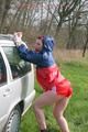 Jill tied and gagged outdoor on a car wearing a sexy red shiny nylon shorts and an oldschool rain jacket (Pics)