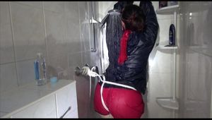 Jill tied and gagged taking a shower wearing sexy shiny nylon shorts and a rain jacket (Video)