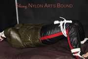Watching Jill being tied on a bed wearing a shiny nylon rain jacket and a down jacket as well as a rain pants being double hooded and gagged with a ballgag (Pics)