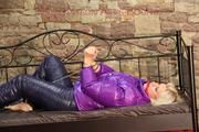 Pia ties and gagges herself on a princess bed wearing a shiny black down pants and a purple down jacket (Pics)