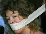 25 YR OLD CHARLENE IS WRAP GAGGED & CHAIR TIED TO A CHAIR WITH WHITE CLOTH MEDICAL TAPE (D47-14)