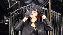 Mistress Tokyo smoking cigarette in leather, gloves and Muir Cap; fetish, POV