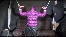 Sexy Sandra being tied and gagged overhead with ropes and a bar wearing a sexy black rain pants and a purple down jacket with hood closed (Video)