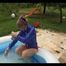 Mara in the swimming pool wearing a sexy red shiny nylon shorts and a lightblue sihny rain jacket playing with the water (Video)