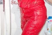 Lucy wearing a sexy red shiny nylon jumpsuit during her shower (Pics)